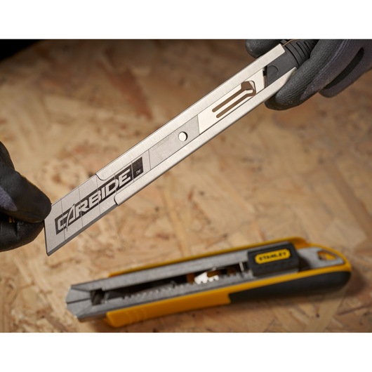 STANLEY STHT0-11825 utility knife with blade extended, yellow and black handle, close-up on wood surface.