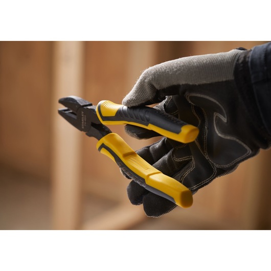 STANLEY STHT0-74367 diagonal cutting pliers with yellow and black handles held by gloved hand.