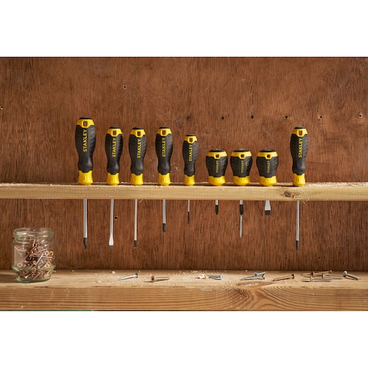 STANLEY STHT16146-0 screwdriver set with yellow and black handles, displayed upright on a wooden shelf.