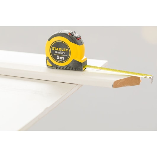 STANLEY STHT36803-0 tape measure on white board, yellow and black casing, 5m length visible.