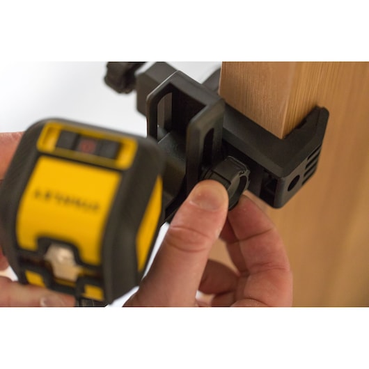 STANLEY STHT77498-1 photography of yellow laser level clamp attached to wooden surface, close-up view.