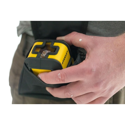 Photo of STANLEY STHT77499-1 yellow and black laser level being placed in a tool pouch.