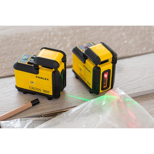 Photo of STANLEY STHT77504-1 CROSS 360 laser level, two units, on wooden surface with green and red laser lines.