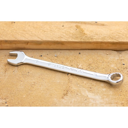 STANLEY STMT82842-0 combination wrench on wood surface, showing open and box ends with chrome finish.
