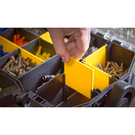 STANLEY STST1-79231 organiser case showing hand adjusting yellow divider, assorted screws inside compartments.