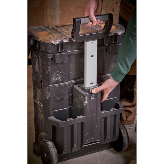 STANLEY STST1-79231 rolling toolbox with extendable handle, photo of person pulling the handle, indoor workshop.